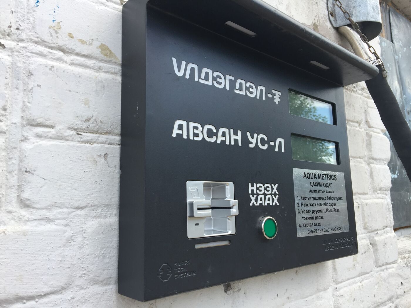 Close-up of the Aqua Metrics terminal with card reader, open and close button and instructions